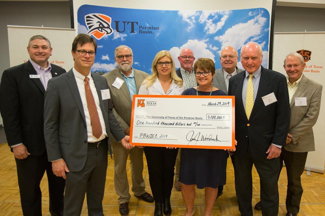 Dr. Woodley accepts check from Permian Basin Water in Energy Conference advisory board