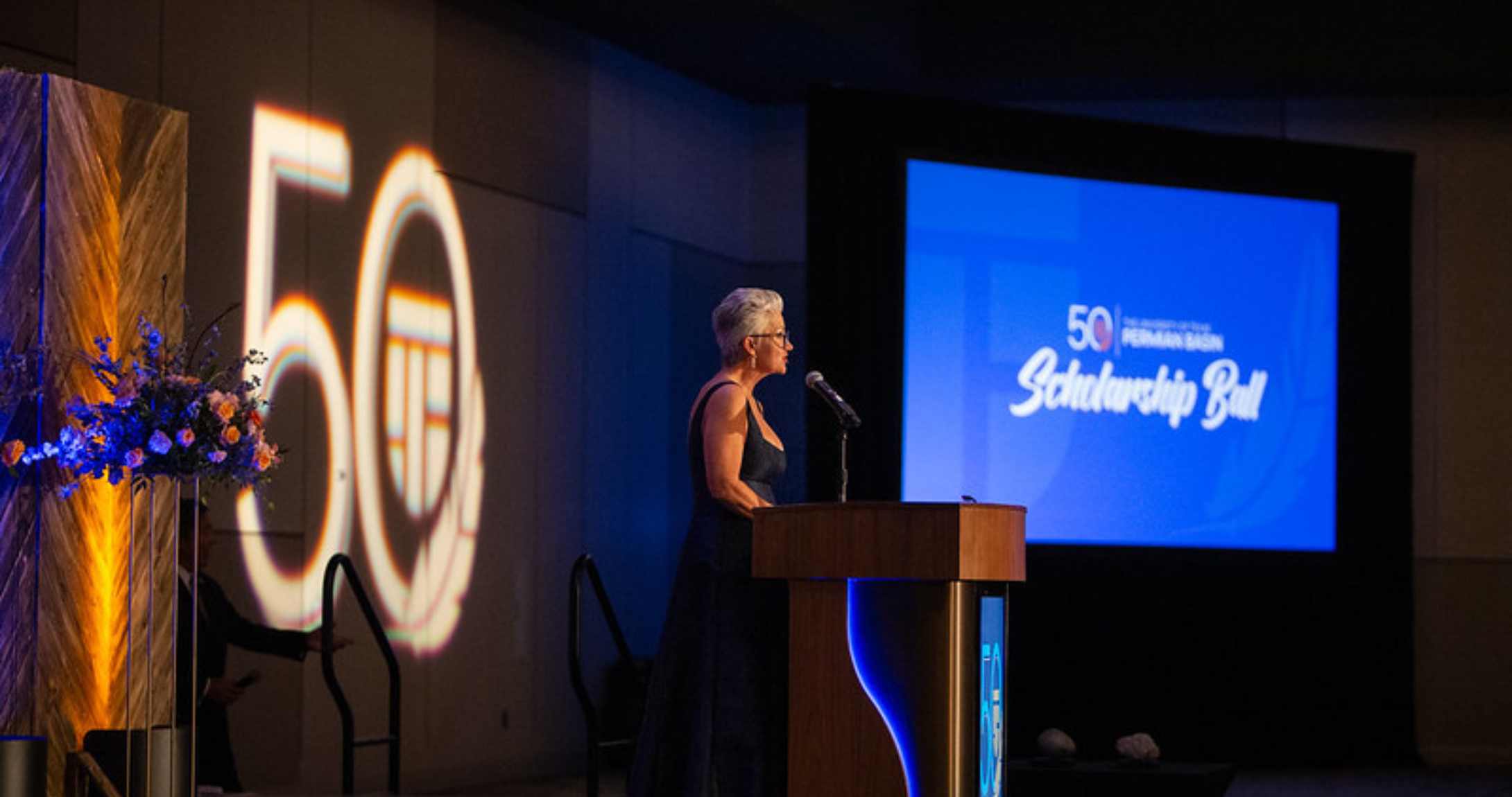 Dr. Woodley speaking at microphone at event