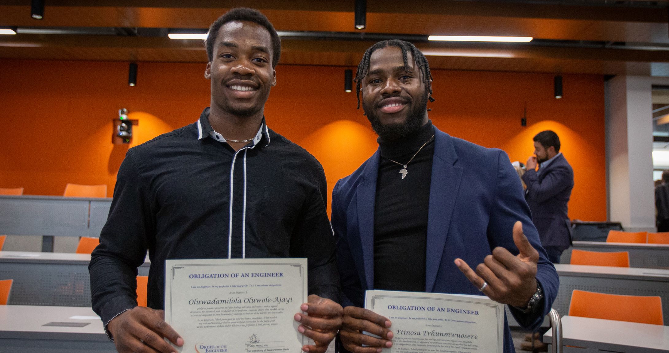 Two engineering students holding their Order of the Engineer certificates