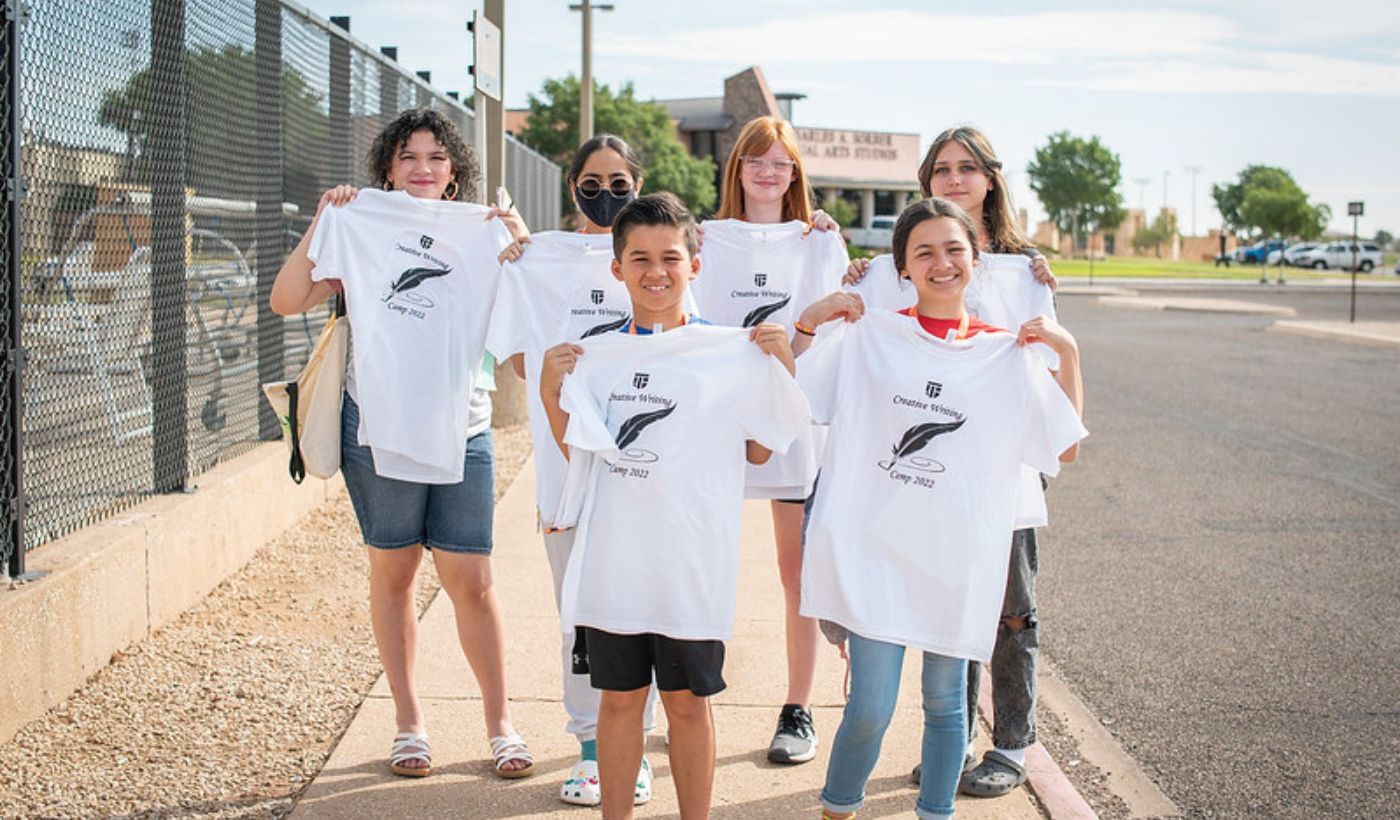 Kids holding up t-shirts