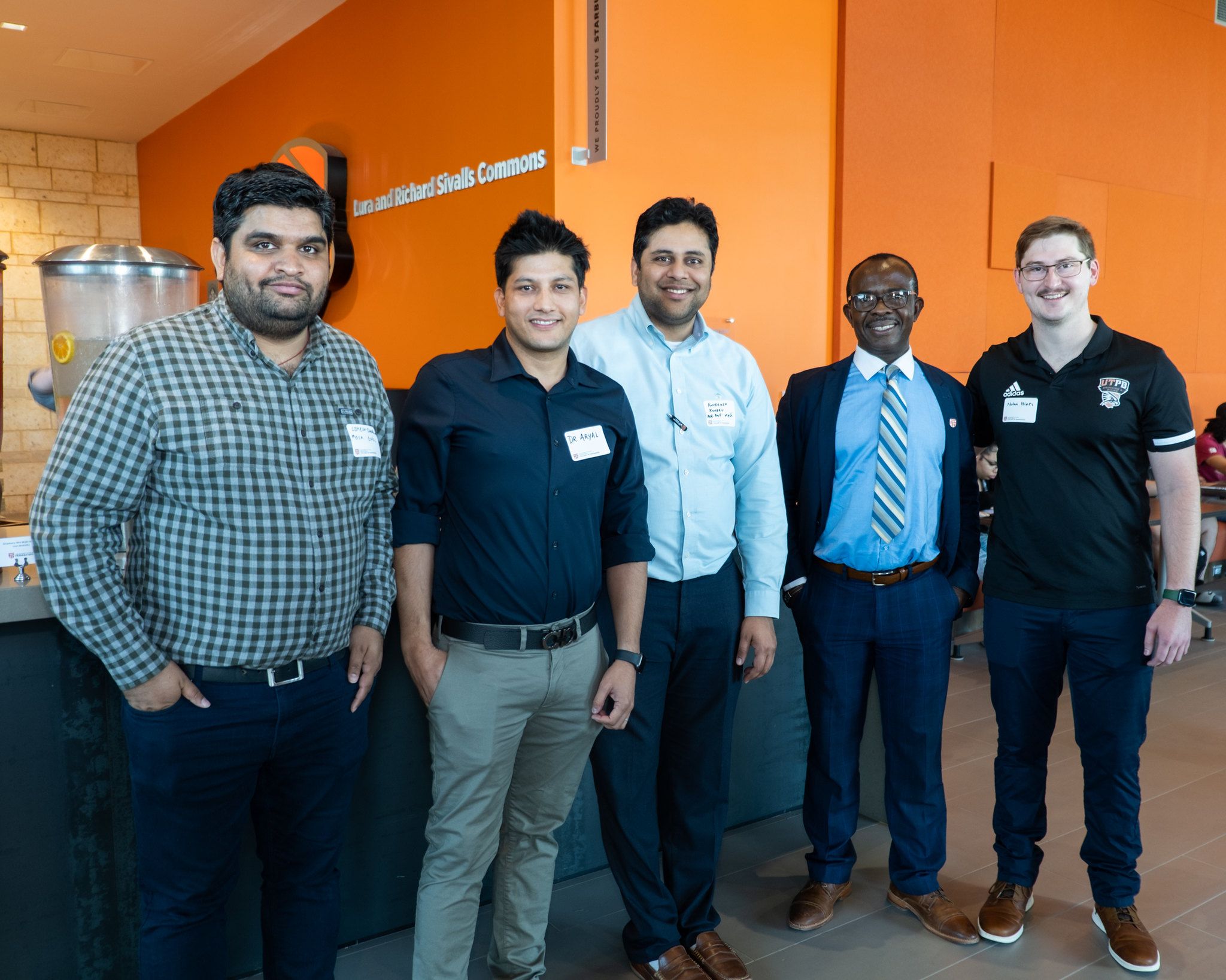 4 faculty members and an alum standing in the lobby of the engineering building