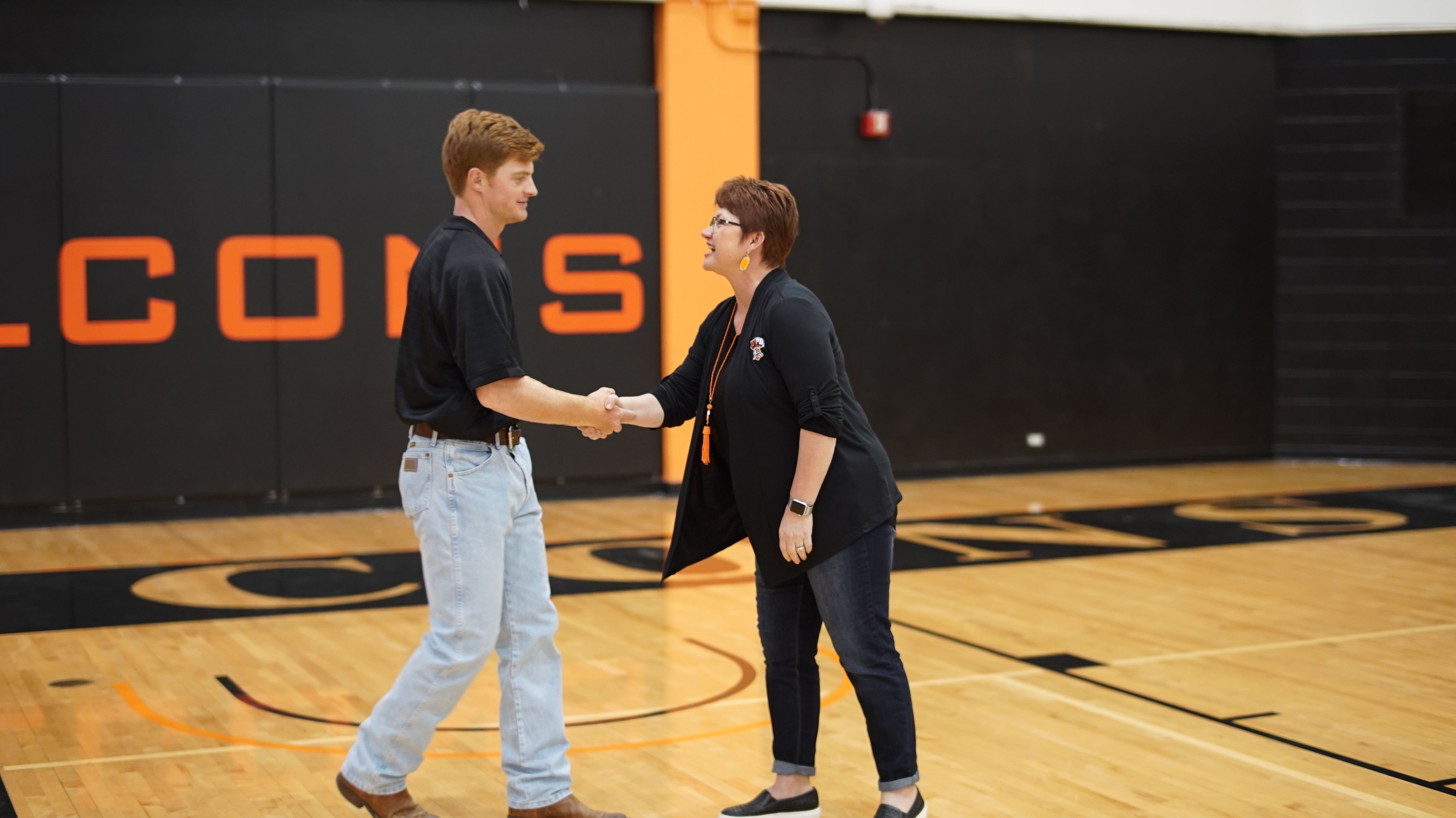 Dr. Woodley shakes hands with student athlete