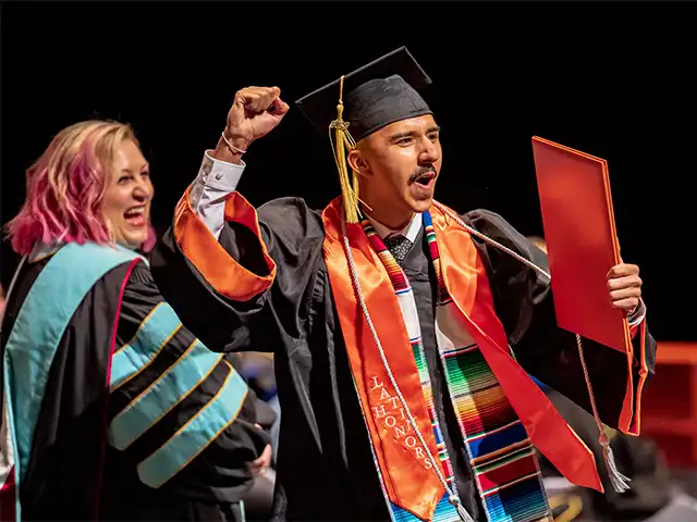 graduate cheering during commencement
