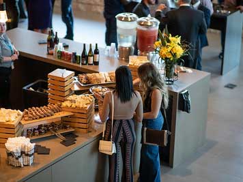 Un evento agradable con dos mujeres poniendo comida en sus platos.